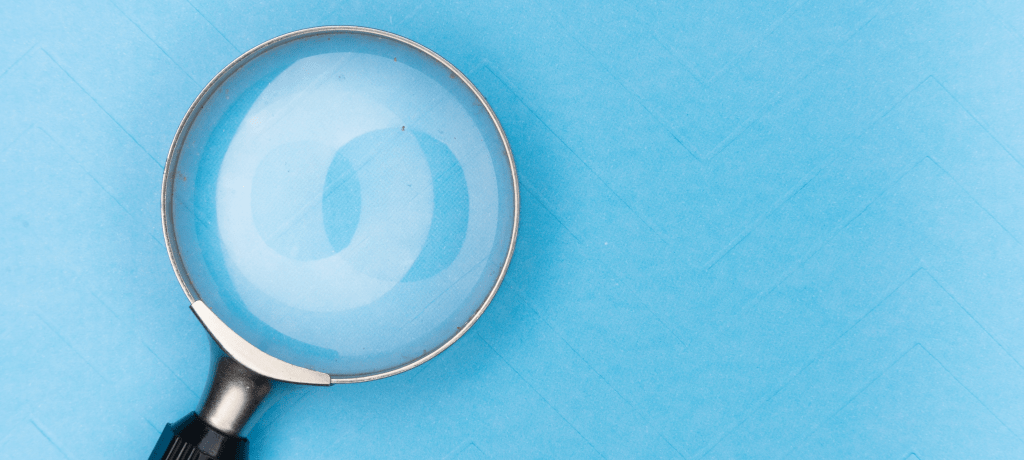 magnifying glass on pastel blue background